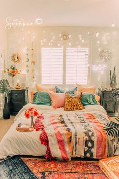 a bed with colorful pillows and blankets on top of it in a room filled with plants