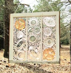 a metal gate in the middle of a forest filled with leaves and flowers on it's sides