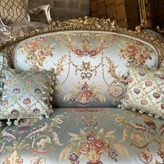 an ornate couch with several pillows on it