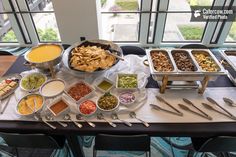 a buffet table filled with different types of food and utensils on it,