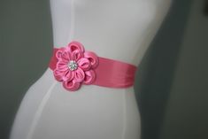 "An accessory to complement your beautiful wedding dress Made of satin fabric with flowers and belt made of satin. In the middle of the flower button is used the crystal. Flower size is approximately 5 \"dimensions. The belt length is approximately 80\"dimensions Flower fitted with lapel pins. Then, a flower can be used as a separate lapel pin. Please feel free to contact for questions and requests. PACKAGE ARE SENT BY FAST SHIPPING COMPANY WITHIN 3 TO 4 BUSINESS DAYS, TO UNITED STATES, TO CANAD Pink Elegant Sash For Formal Occasions, Pink Bridal Belt With Sashes For Party, Elegant Pink Bridal Belt With Sashes, Elegant Fitted Pink Sashes, Elegant Bridal Belt With Flower Decoration, Pink Sashes Bridal Belt For Wedding, Elegant Bridal Belt With Handmade Flowers, Elegant Sashes With Handmade Flowers For Party, Elegant Handmade Flower Sashes For Party