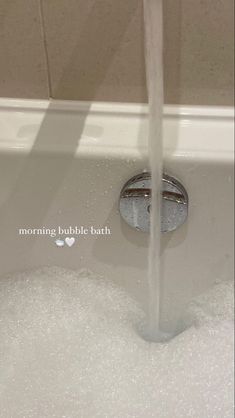 a close up of a faucet in a bathtub filled with foam and bubbles