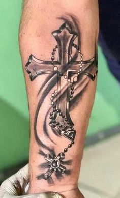 a man's arm with a cross tattoo on it