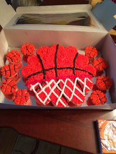 cupcakes shaped like basketballs are in a box on a table with other items