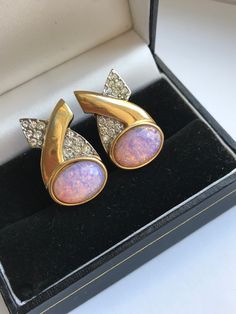 Vintage large clip earrings are labeled BG (Bergdorf Goodman).  Clip earrings with pink opal cabochon in the style of the 80s. The metal base is brass with a gorgeous gold plated finish.   Size: 26/15 mm, weight of both clips is 16 grams.  Overall condition is very good, no defects, but considering the age there are traces of time.  Careful packing of items! The letter will be sent within 1-2 days by Polish public service, delivery will take 1-2 weeks on average. Vintage Bg, Luxury Cabochon Clip-on Earrings For Women, Luxury Oval Cabochon Clip-on Earrings, Vintage Formal Clip-on Cabochon Earrings, Vintage Jeweled Metal Clip-on Earrings, Vintage Yellow Gold Cabochon Clip-on Earrings, Luxury Vintage Cabochon Clip-on Earrings, Rose Dans, Vintage Gold Clip-on Earrings With Rhinestones