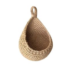 a small basket hanging from the side on a white wall with a hook in it