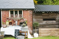 an outdoor bar set up in front of a brick building with potted plants on it