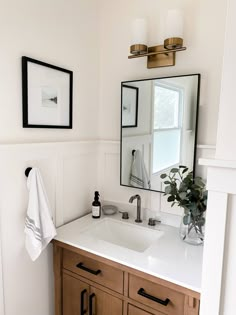 a bathroom sink with a mirror above it and a towel hanging on the wall next to it