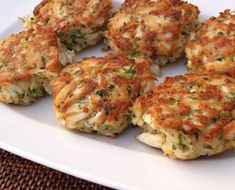 several crab cakes are arranged on a white plate