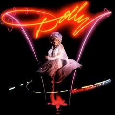 an advertisement for dolly on the side of a building with neon lights and a woman in a white dress