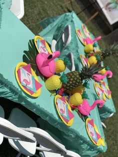 a table with pineapples and flamingos on it at a birthday party or baby shower