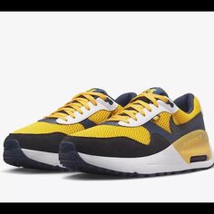 Elevate Your Sneaker Game With These Nike College Air Max Systm Michigan Men's Shoes In Amarillo/Navy. Designed For Athletic And Casual Wear, These Shoes Feature A Lace-Up Closure And Low-Top Shoe Shaft Style For A Secure And Comfortable Fit. The Rubber Outsole Provides Traction While The Arch Support, Cushioning, And Lightweight Design Make These Shoes Ideal For Gym & Training, Walking, School, Cross-Training, Athleisure, Casual, And Running & Jogging.Celebrate Your Love For The University Of M Yellow Lace-up Sneakers With Air Cushioning, Yellow Dynamic Sneakers With Round Toe, Navy Lace-up Sneakers With Air Cushioning, Dynamic Yellow Sneakers With Boost Midsole, Navy Running Shoes With Air Cushioning And Round Toe, Yellow Low-top Basketball Shoes With Air Max Cushioning, Navy Running Shoes With Air Cushioning, Navy Running Shoes With Air Cushioning Lace-up, Yellow Running Shoes With Rubber Waffle Outsoles For Sports