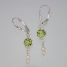 Peridot and dainty Pearl Earrings Secure lever backs Stone size 5mm approx 1.3 inch approx Handmade Peridot Round Earrings, Handmade Round Peridot Earrings, Elegant Peridot Earrings With Ear Wire, Elegant Peridot Dangle Earrings, Peridot Dangle Earrings With Ear Wire, Dainty Pearl Earrings, Peridot Jewelry, Peridot Earrings, Earrings Pearl