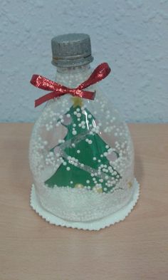 a glass bottle with a christmas tree inside