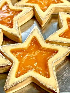 star shaped cookies with orange jelly filling on a metal tray in the shape of stars