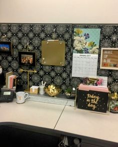 an office desk with a calendar, coffee cup and other items on the counter top