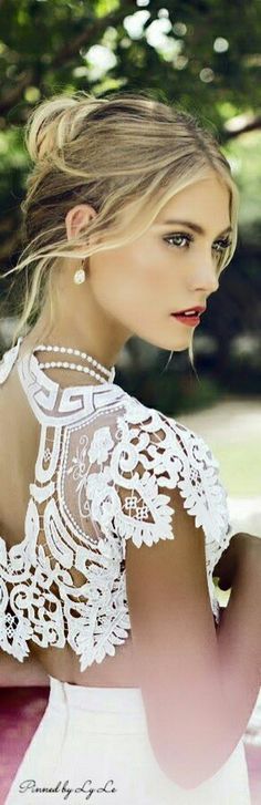 a woman in a white dress is sitting on a bench with her back to the camera