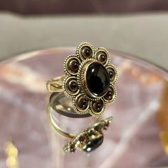 Indulge in the allure of contrasting textures and sophisticated design with our Ladies Sterling Silver Multi-Stone Ring. This exquisite piece features a mesmerizing onyx center stone surrounded by an array of complementary gemstones, all set in a beautifully crafted sterling silver band. The focal point of this ring is a rich, black onyx, radiating a sense of mystery and elegance. The onyx is carefully set within the sterling silver setting, creating a striking contrast that captures attention. Formal Black Rings With Gemstone Accents, Elegant Black Rings With Gemstone Accents, Black Rings With Gemstone Accents As Gift, Black Rings With Gemstone Accents For Gift, Elegant Oval Cabochon Rings With Natural Stones, Elegant Formal Rings With Natural Stones, Antique Onyx Ring With Gemstone, Heirloom Black Ring With Cabochon, Contrasting Textures