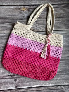 a crocheted handbag with a tasseled handle on a wooden surface