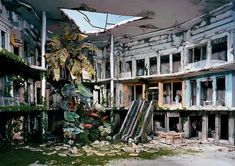 an abandoned building with lots of windows and plants