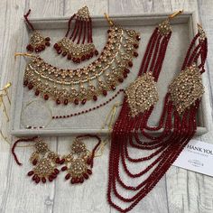 an assortment of red and gold jewelry on display