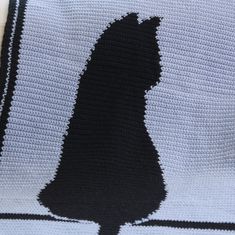 a crocheted blanket with a black silhouette on it