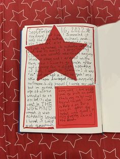 an open book with writing and a red star on it