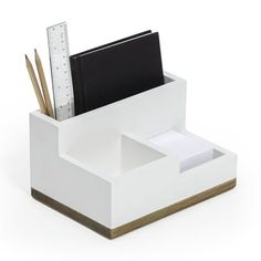 a white desk organizer with a ruler and pencils in it on a white background