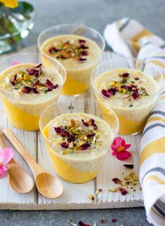 three glasses filled with dessert sitting on top of a table