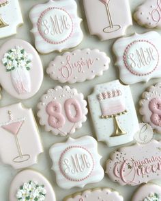 decorated cookies with pink and white frosting are arranged on a countertop for a celebration