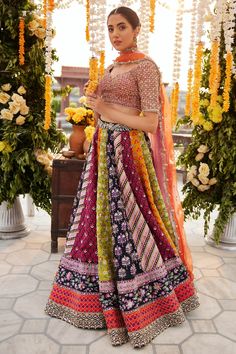 Indian Bridal Dress in Multicolored Lehenga Choli Dress is an embellished attire that will give the gorgeous bride a trendy as well as traditional bridal look. The lavish blend of colors and hand-crafted details of ornaments make this Lehenga Choli an epitome of beauty. Bridal Choli: The choli comes in an alluring blend of orange and purple shades. This stunning choli is adorned with tilla, gotta, and shimmering ornaments, making it a perfect choice to pair with the huge flared bridal lehenga, c Multicolor Bohemian Georgette Sharara, Reception Lehenga With Multicolor Embroidery In Georgette, Multicolor Georgette Reception Dress, Multicolor Embroidered Georgette Lehenga With Dupatta, Georgette Lehenga With Multicolor Embroidery And Dupatta, Multicolor Embroidered Georgette Lehenga, Multicolor Georgette Saree Dress, Multicolor Anarkali Set For Reception, Multicolor Georgette Choli With Intricate Embroidery