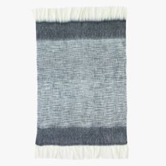 a gray and white rug with fringes on the bottom, against a white background