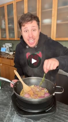 a man stirring food in a pan on top of a stove