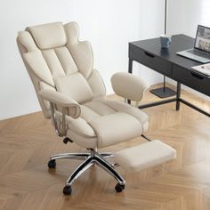 an office chair and footstool in front of a desk with a laptop on it