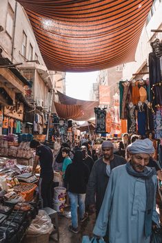 an outdoor market with people walking around it