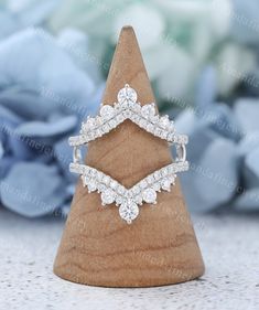 a diamond ring sitting on top of a wooden stand