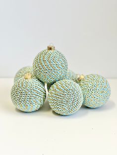 four blue and white balls sitting on top of each other in front of a white wall