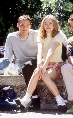 three people sitting on a bench in the park