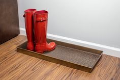 a pair of red rain boots sitting on top of a metal tray