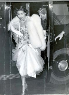 an old black and white photo of a woman in a dress with fur stoler