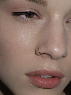 a close up of a woman with piercings on her nose