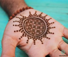 a person's hand with a hendi design on it, and beads around the palm