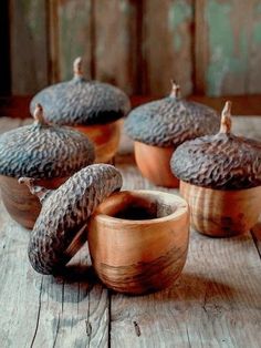 wooden bowls filled with acorns on top of a table