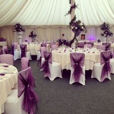 the tables are covered with purple and white linens