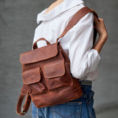 Genuine leather minimalist backpack. Zipper closure and large front pocket. DIMENSIONS: MEDIUM - 26 cm (10.2 inch) x 24 cm (9.5 inch) LARGE - 36 cm (14.2 inch) x 35 cm (13.8 inch) - Carabiner closure on the flap; - Adjustable shoulder straps; - Top carrying handle; - Laptop section can be added upon request. Eight colors are available. Your item may be personalized according to your wish. See the banners for more information. Leather School Backpack With Pockets, Everyday Backpack With Pockets, Modern Backpack With Pockets For Everyday Use, Rectangular Leather Backpack With Pockets For Everyday Use, Daily Use Leather Backpack With Pockets, Waxed Finish Satchel Backpack For School, Leather Backpack With Pockets, Canvas Backpack With Pockets, Everyday Leather Backpack With Pockets