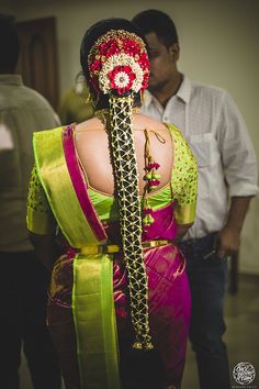 a woman in a colorful sari with her back to the camera, wearing a flowered headpiece