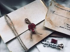 an old envelope with a wax stamp and some other items on the inside are tied up