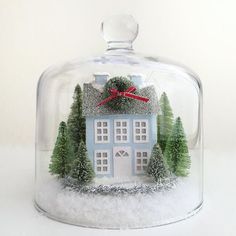 a glass cloche with a house under it