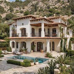 a large house with a pool in front of it and lots of greenery on the outside