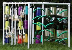 a rack with pots and pans hanging from it's sides in the grass